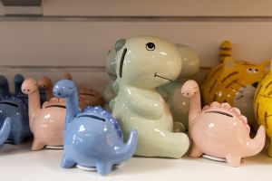 Keramik-Spardosen in Form kleiner Dinosaurier in Rosa, Hellblau und Pastellgrün.