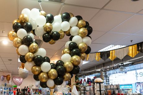 Dekoratives Herz aus, kleinen weißen, schwarzem und goldenen Ballons