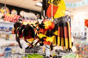 Verkaufsständer mit Fanartikeln in Schwarz-Rot-Gold, darunter Blumenketten, Haarreifen und Schweißbänder.