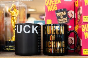 Große schwarze Keramiktassen mit goldener und weißer Aufschrift, darunter „Queen of Fucking Everything“.#