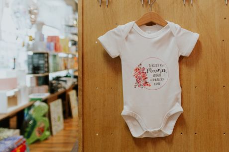 Weisser Baby Body mit grafisch gestaltetem Aufdruck: „Du bist die beste Mama, die man sich wünschen kann.“